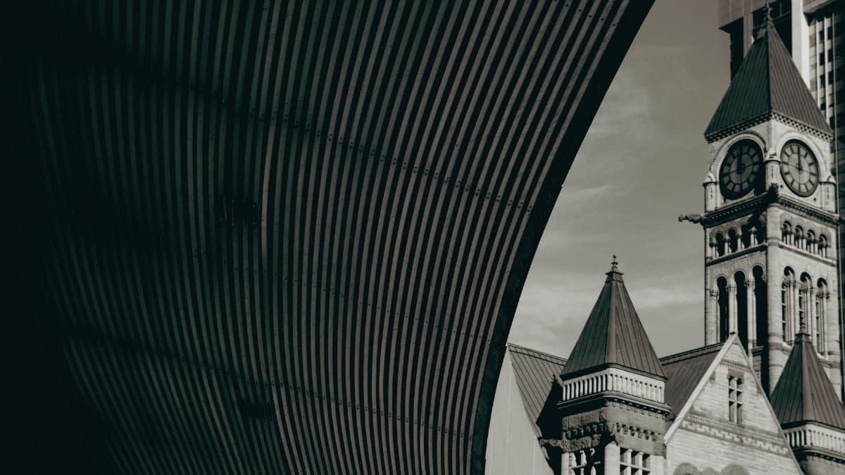 A vintage view of Toronto's Old City Hall tower with urban architecture.