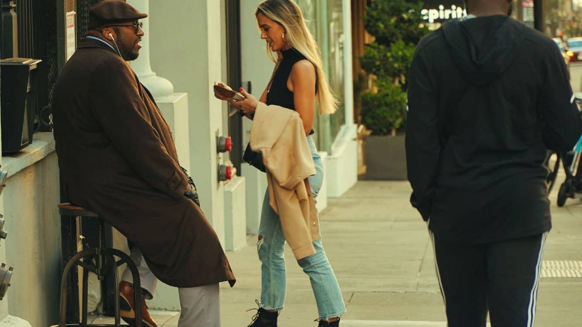 Candid moment of people interacting on a city sidewalk during the day.