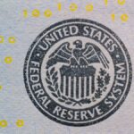 Detailed view of the US Federal Reserve System seal on currency with yellow digital numbers.