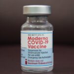Detailed view of a Moderna COVID-19 vaccine vial, highlighting immunization efforts.