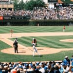 Vibrant scene of a baseball game at Wrigley Field with packed grandstands and players in action.