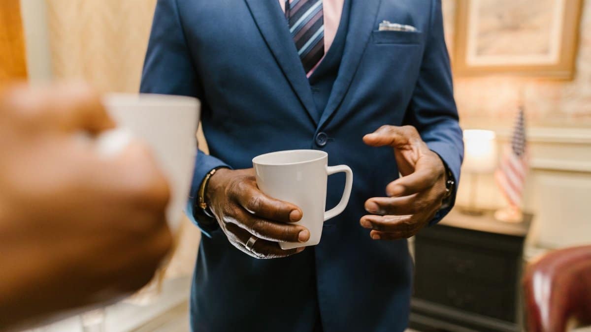 Two professionals engaging in conversation over coffee during a business meeting.