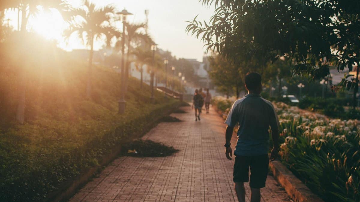 A peaceful walkway at golden hour in Buon Ma Thuot, Vietnam with people enjoying a sunset stroll.