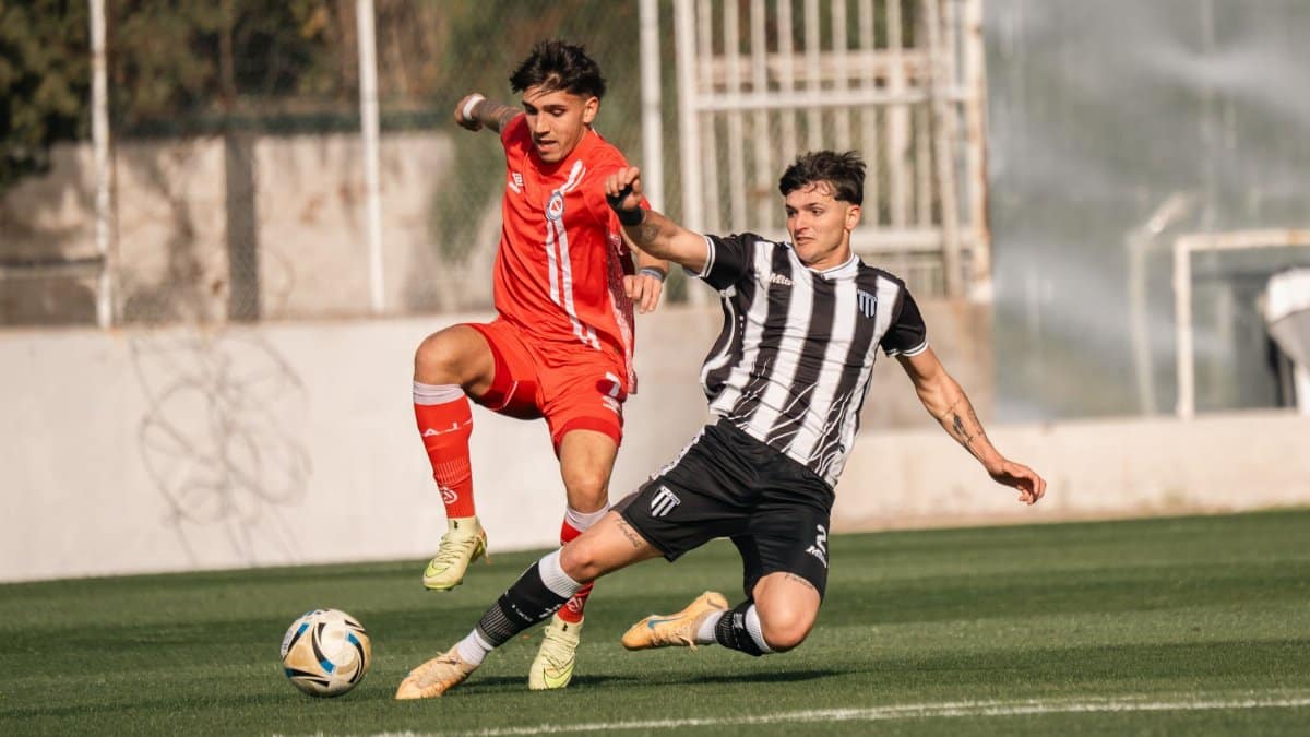 Two soccer players vie for the ball during an intense outdoor match.