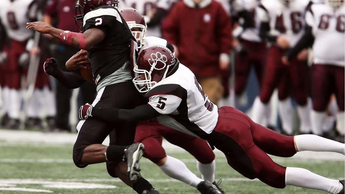 Exciting tackle during an American football game highlighting teamwork and athletic skill.
