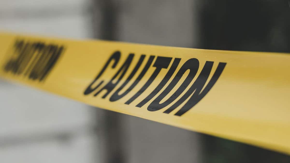 Close-up image of yellow caution tape with blurred background, emphasizing warning and safety.