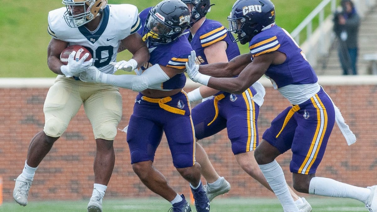 College football players in action on the field, showcasing teamwork and competition.