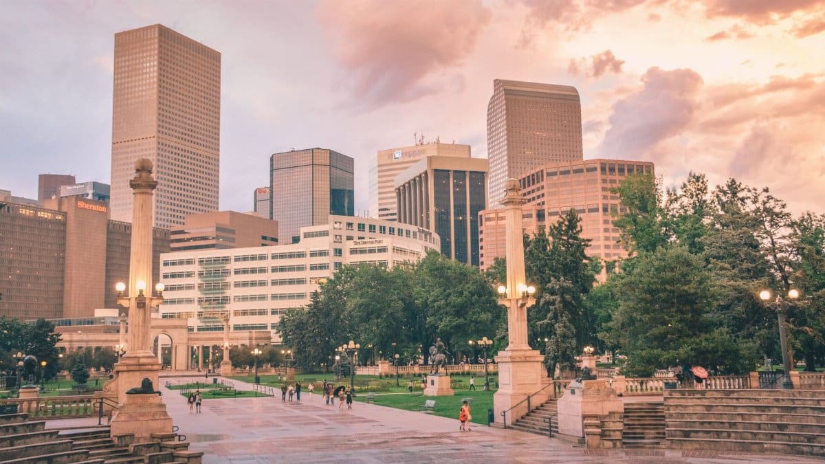 Stunning view of Denver's skyline with city park and people at sunset.