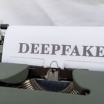 Old-fashioned typewriter with a paper labeled 'DEEPFAKE', symbolizing AI-generated content.