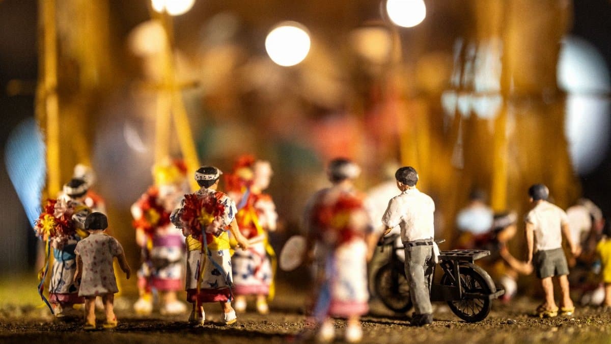 Captivating miniature scene depicting a Japanese festival with figures and a motorbike under warm lighting.