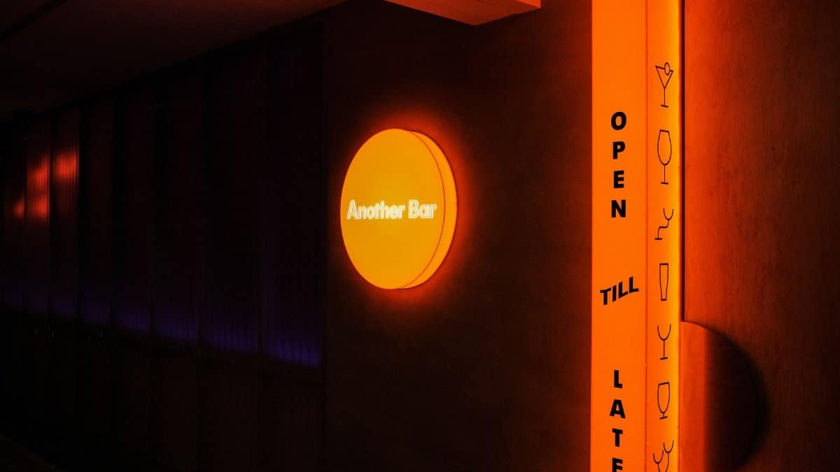 Vibrant neon signage for 'Another Bar' with a stylish design, open till late at night.