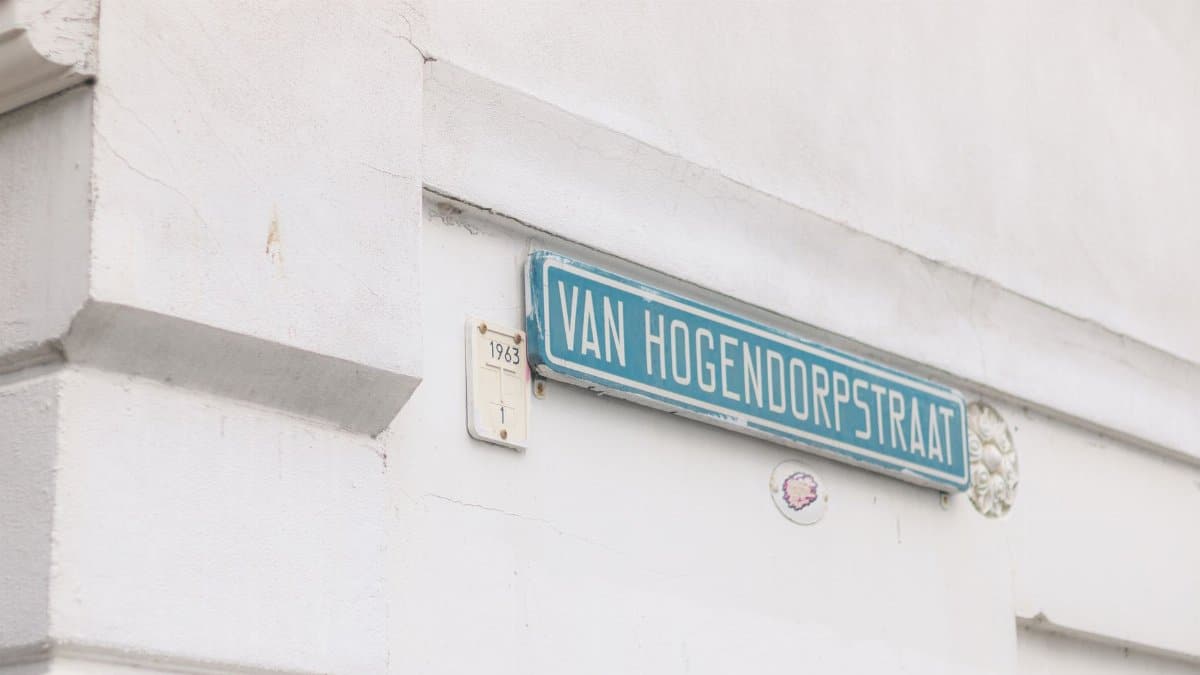 Close-up of Van Hogendorpstraat street sign on a textured white wall, providing urban aesthetic.