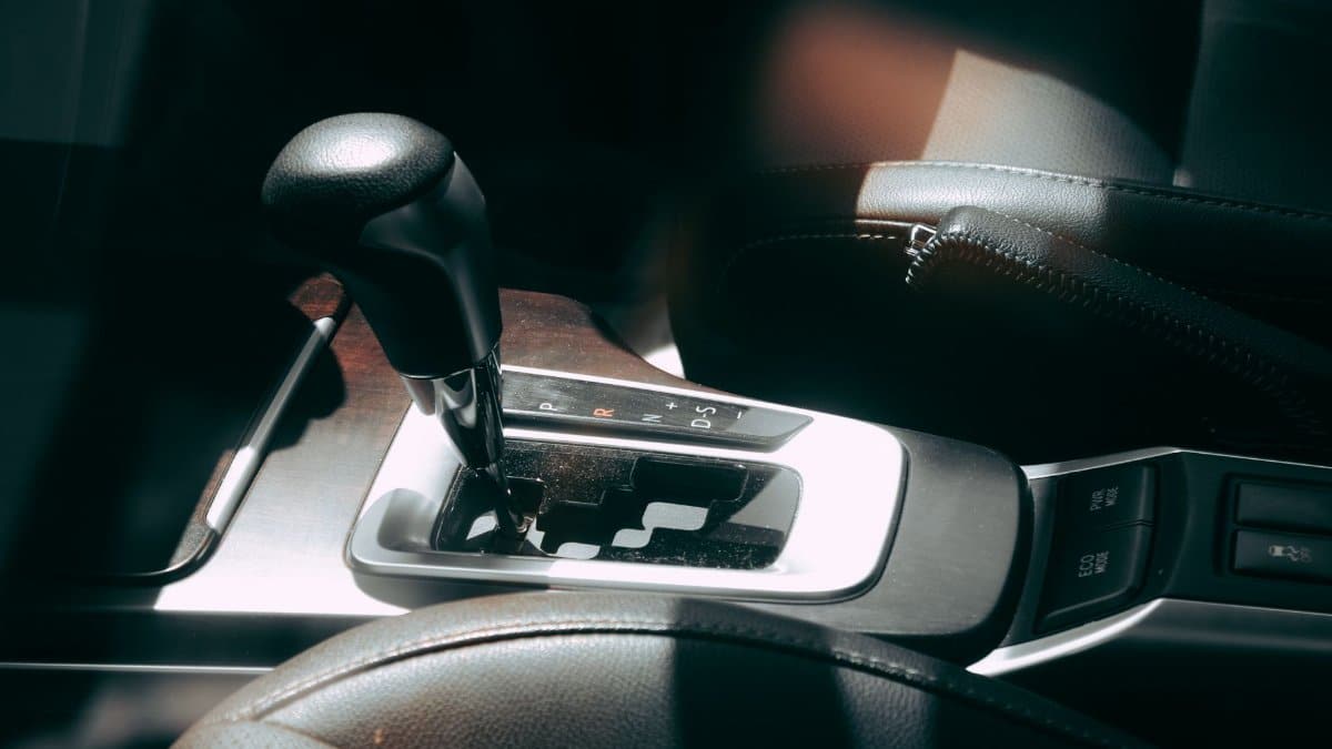 Close-up of a car's gear shift lever and interior, showcasing elegance and design.