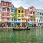 Vibrant facades line a canal with a gondola, capturing colorful urban scenery reminiscent of Venice.
