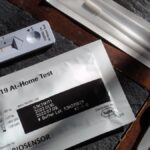 Close-up of a COVID-19 at-home test kit with packaging and test components displayed.
