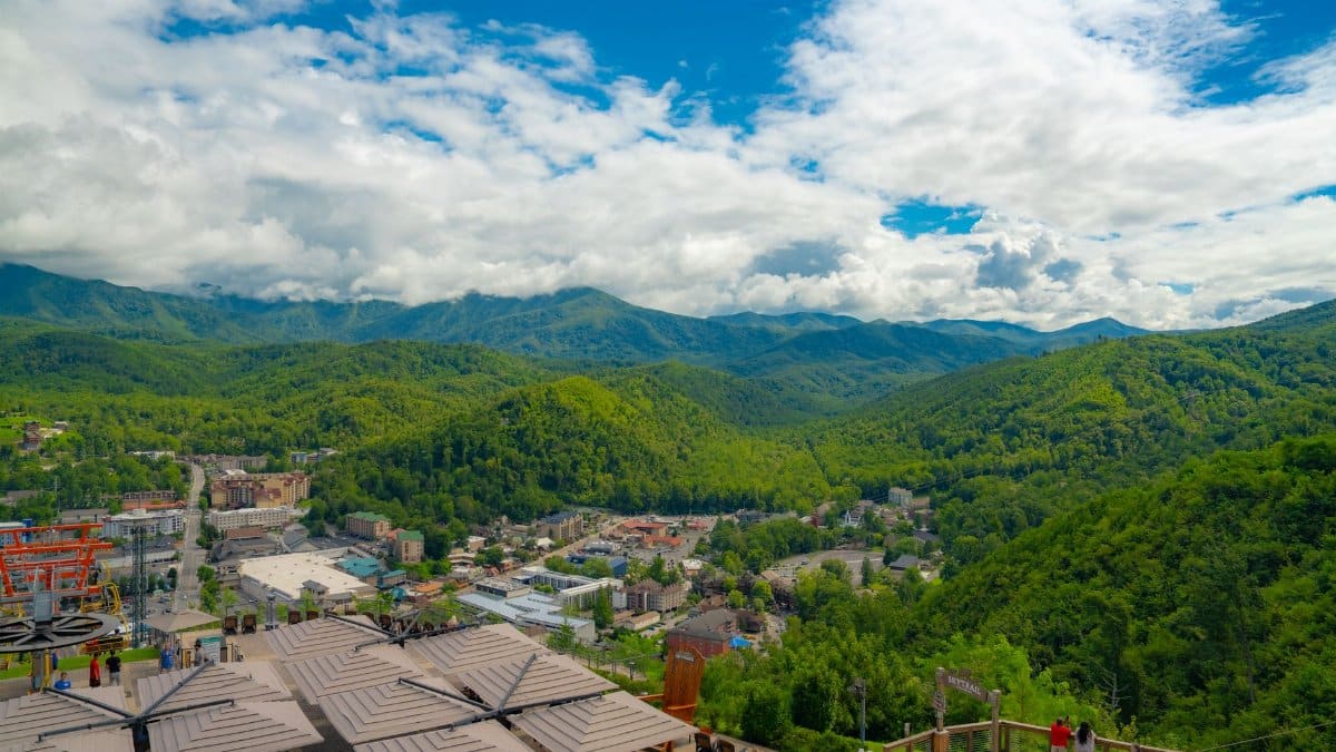 Breathtaking aerial view of lush Smoky Mountains and Gatlinburg cityscape during summer.