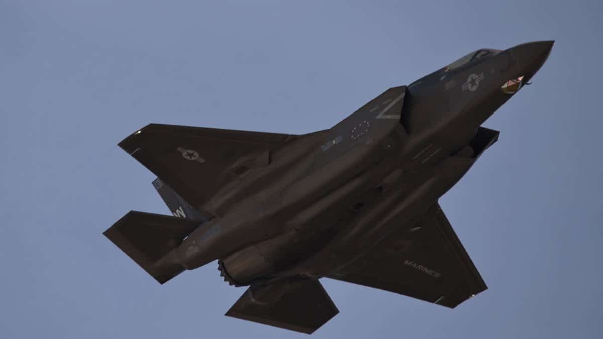 High-speed military jet flying through a clear blue sky at March Air Reserve Base.