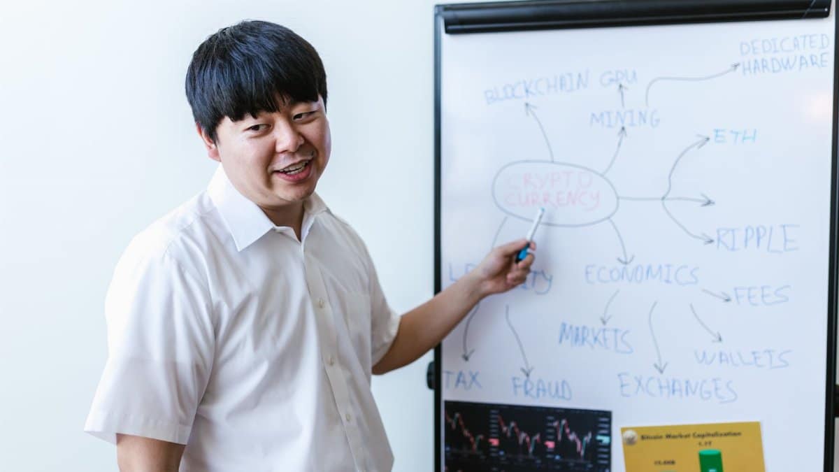 A professional explaining cryptocurrency concepts on a whiteboard during a seminar.