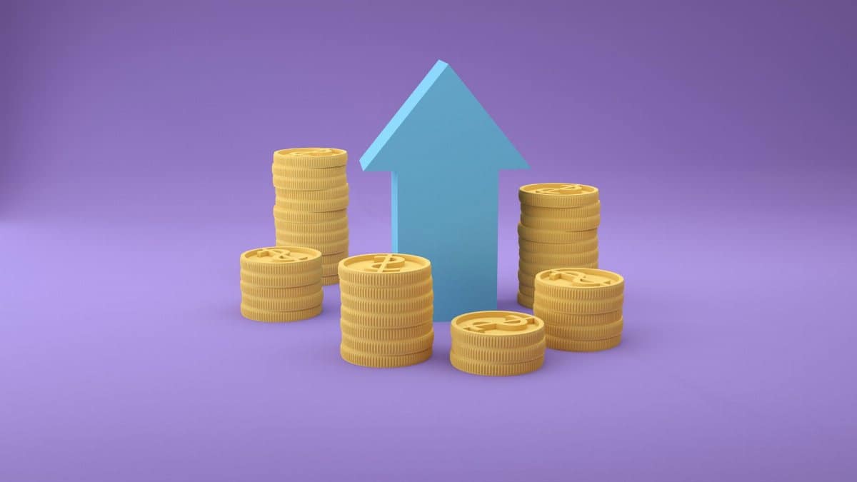 Stacks of coins with an upward arrow symbolizing financial growth and success.