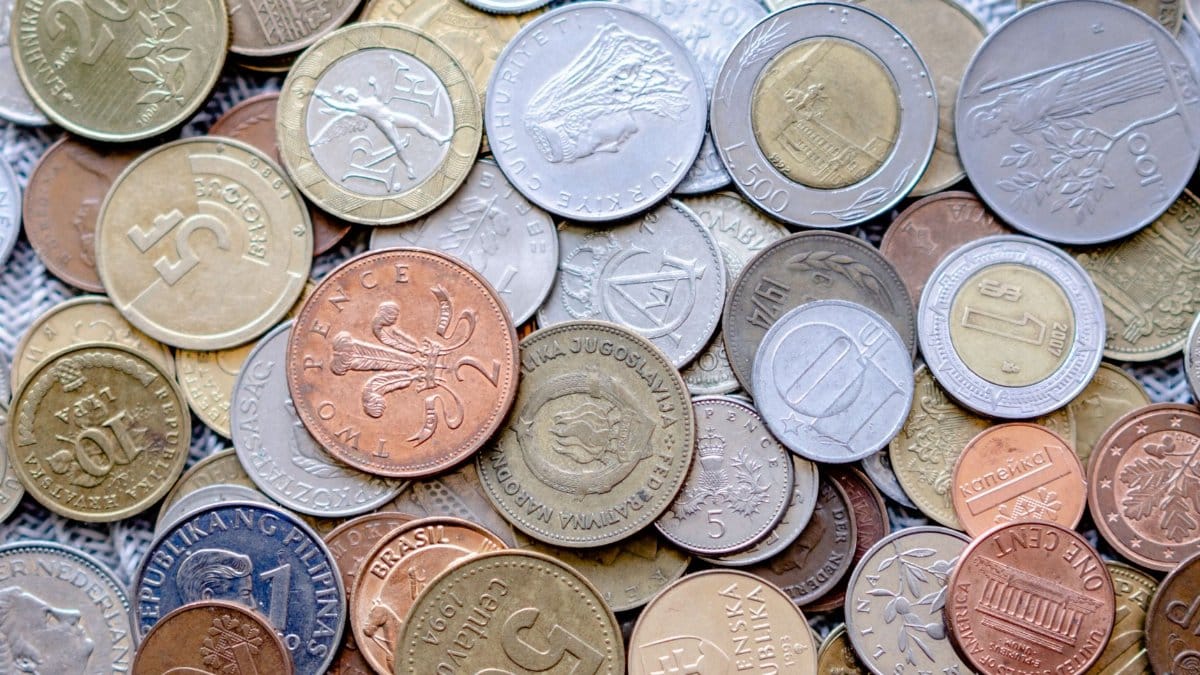 Colorful collection of international coins in various denominations and currencies.