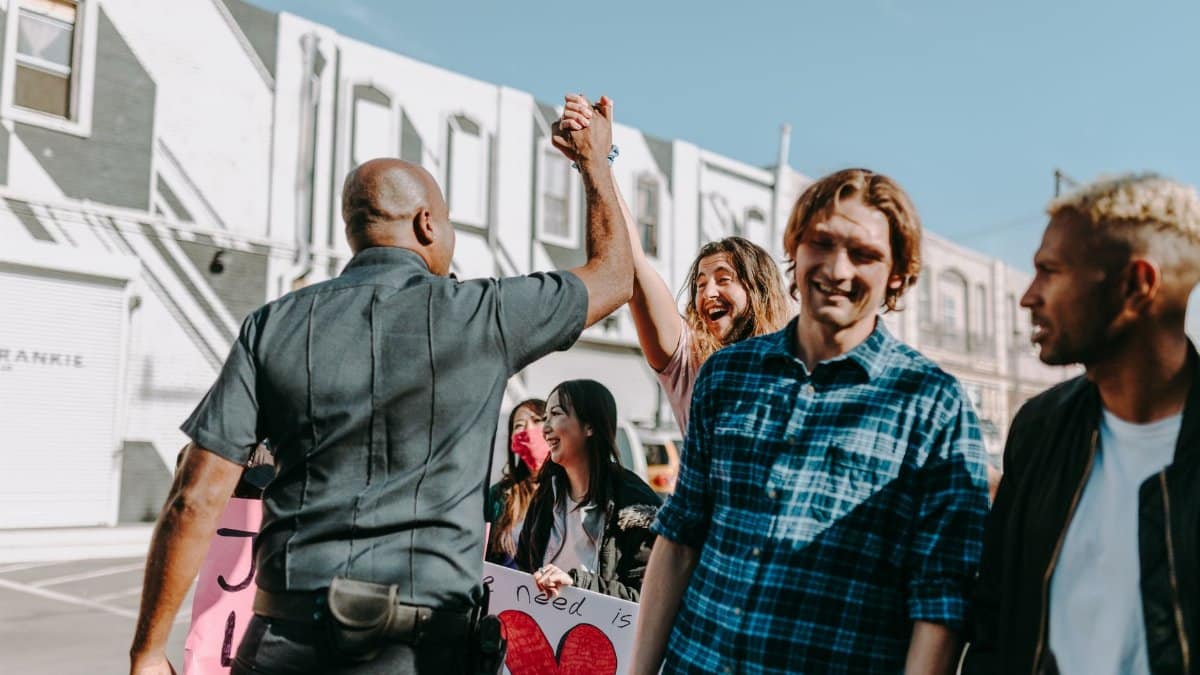 A joyful moment during a protest as a police officer and a protester share a high five.