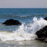 Photograph of powerful ocean waves crashing against rocky formations in Carpinteria, California.