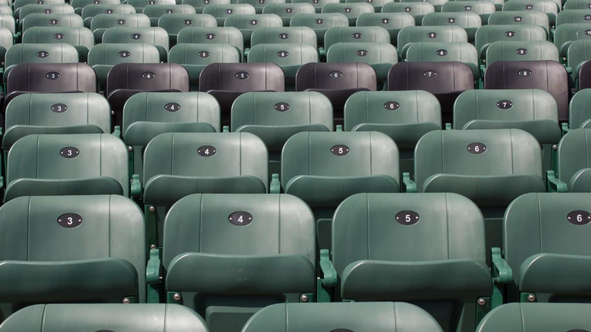 Rows of empty green stadium seats with unique numbers in Québec, Canada.
