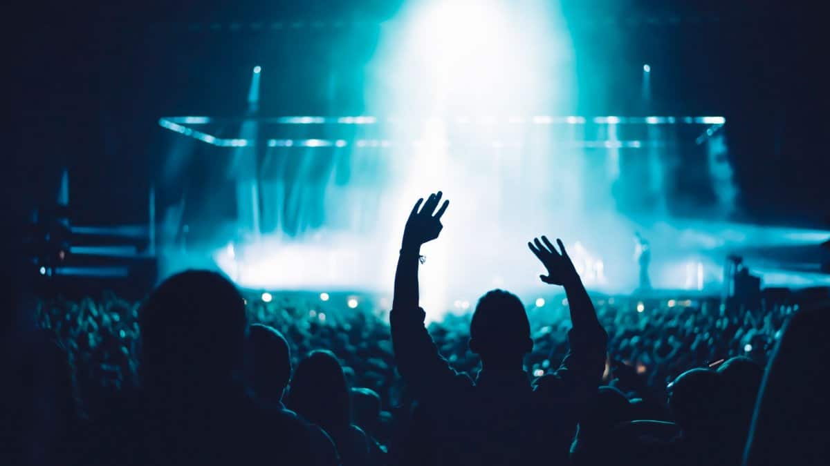 High-energy live music concert with crowd and vibrant stage lighting creating a dramatic atmosphere.
