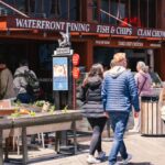 Lively waterfront dining area in San Francisco, featuring people enjoying a sunny day and popular food spots.
