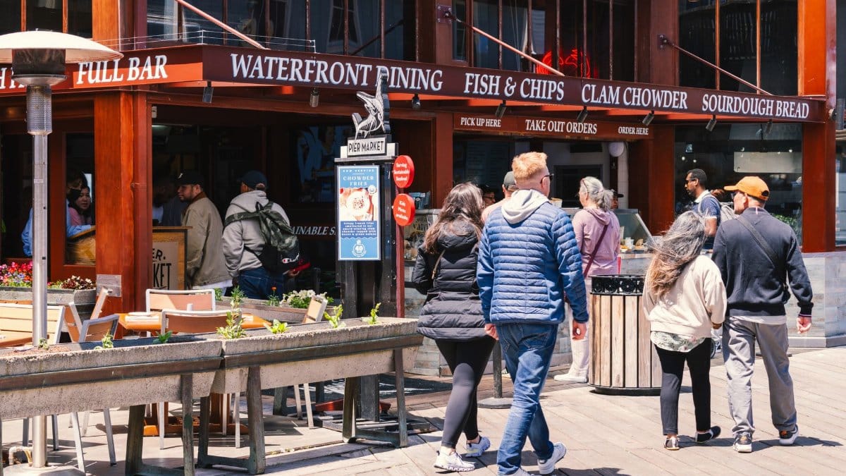Lively waterfront dining area in San Francisco, featuring people enjoying a sunny day and popular food spots.