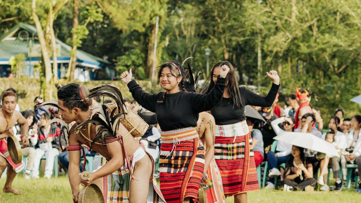 Colorful traditional dance performance featuring vibrant clothing at an outdoor cultural event.