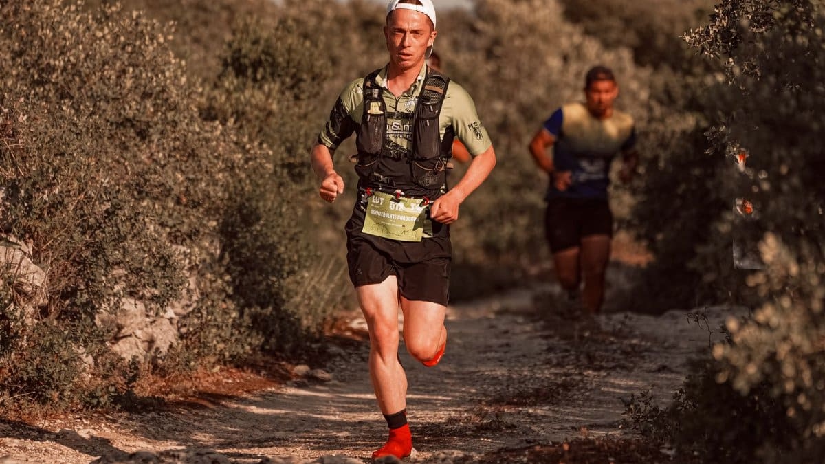 Two men trail running on a rugged rural path, engaged in a competitive race.