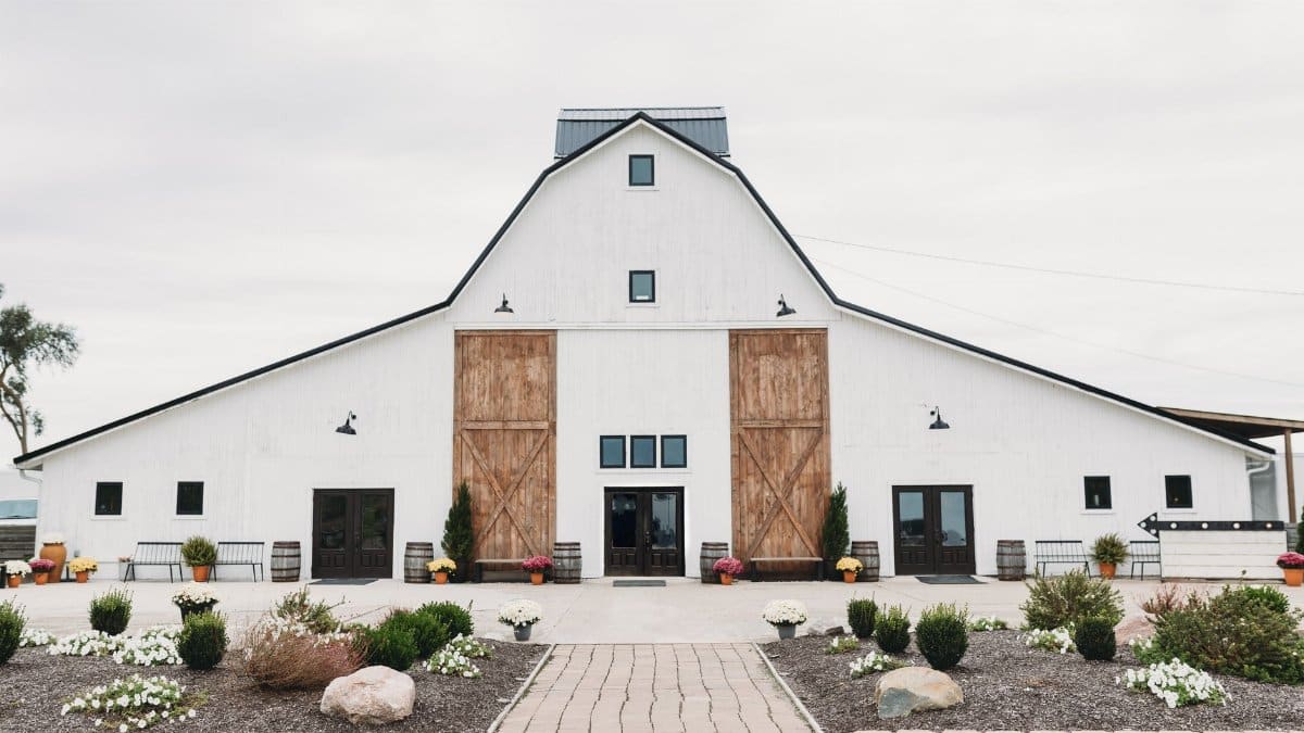 A spacious white barn serving as a venue, showcasing rustic architecture and countryside charm.