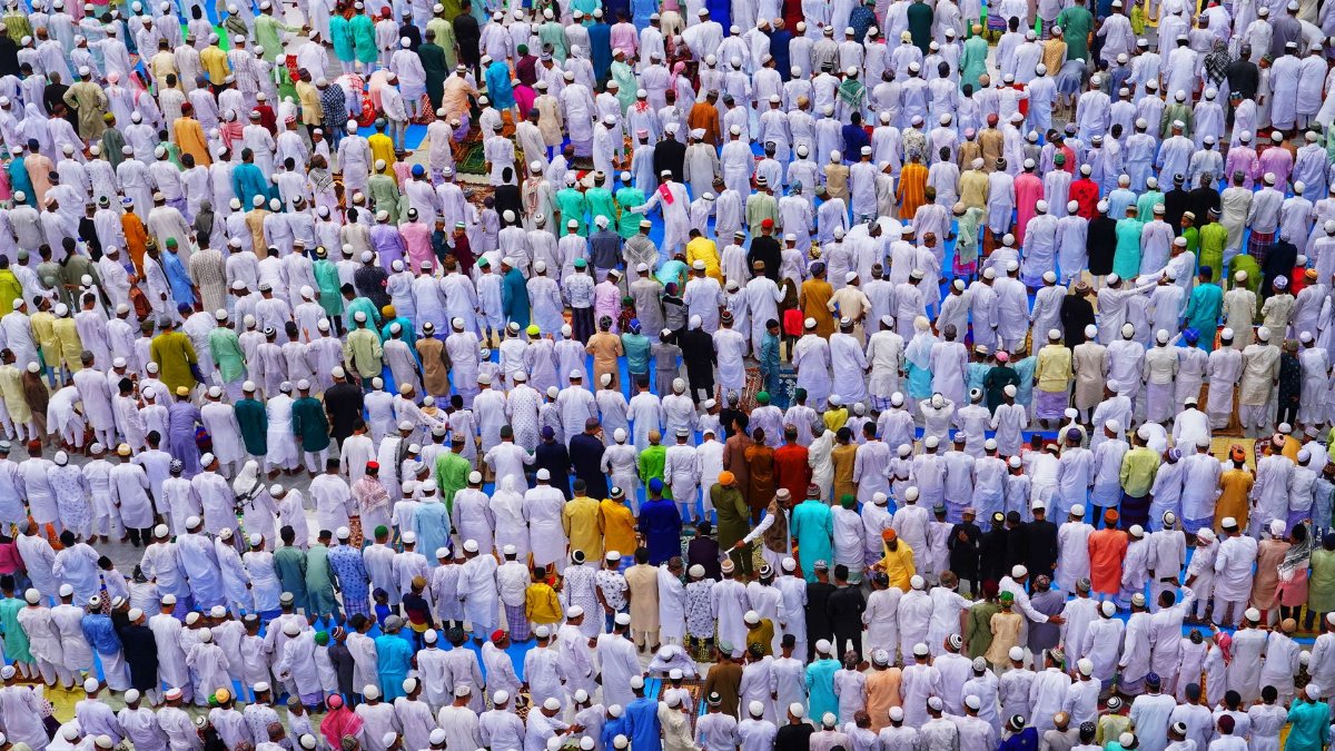 A vibrant aerial photo capturing a large crowd in traditional attire during a religious prayer event.