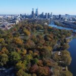 Stunning aerial shot of Philadelphia's skyline with Fairmount Park and Schuylkill River in fall colors.
