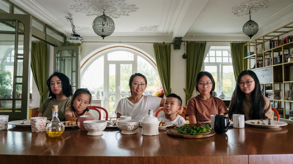 A diverse family enjoying dinner together in a cozy living room setting.