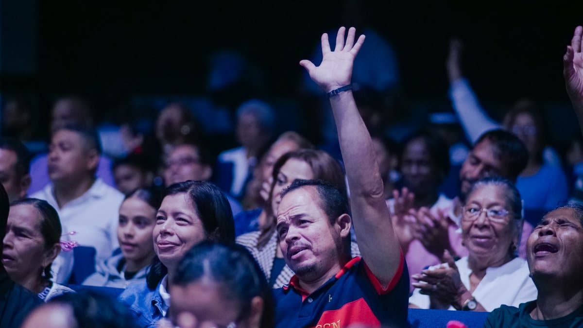 Diverse group of people in a congregation, engaging in prayer and spirituality.