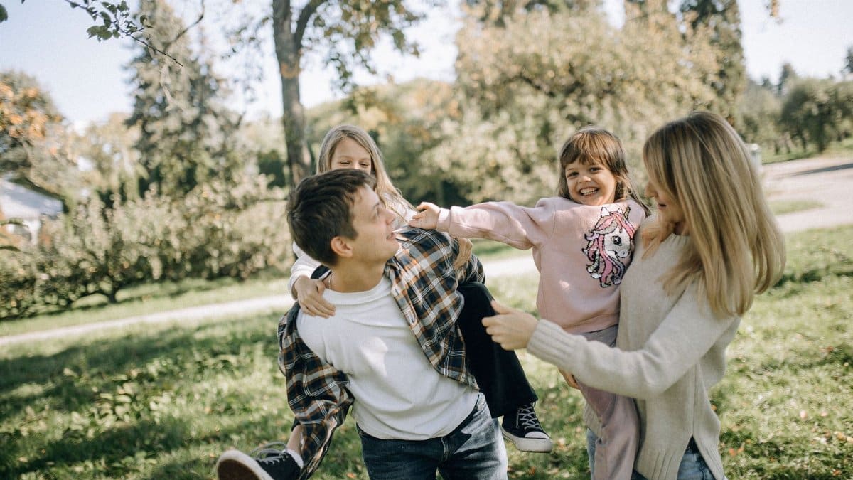 A joyful family spending quality time together in a green park on a sunny day.