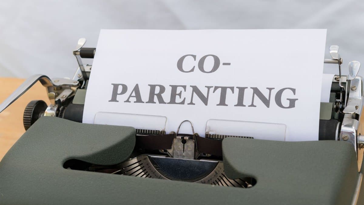 A vintage typewriter displaying a paper with the word 'Co-Parenting', symbolizing shared parenting or custody.