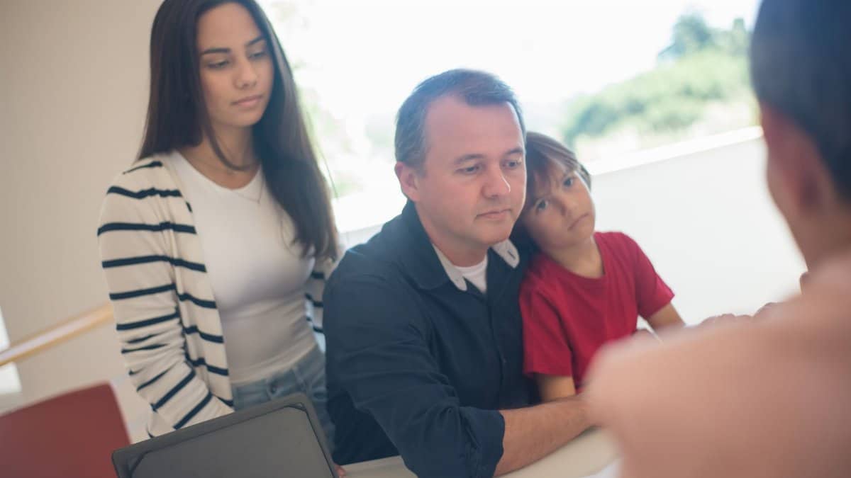 A family meeting indoors with a realtor discussing real estate options, emphasizing family and communication.