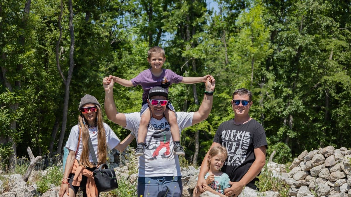 A joyful family enjoying a sunny day outdoors, captured in a lively and happy moment.