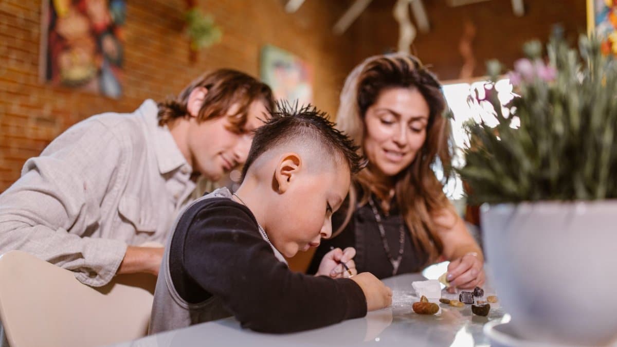 A family engages in creative play activities indoors, fostering bonding and motor skills.