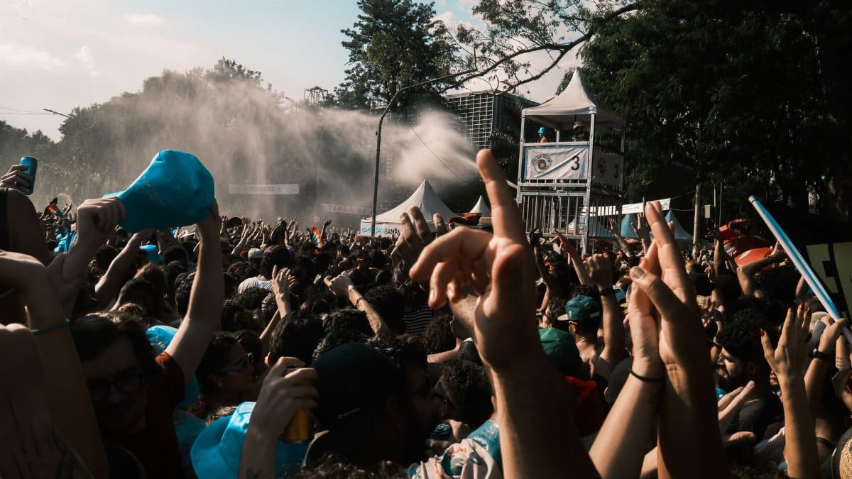 Vibrant crowd enjoying an outdoor music festival on a sunny day.