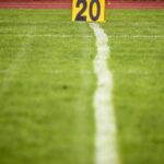 Close-up view of a football field with a 20-yard marker, showcasing vibrant green grass.