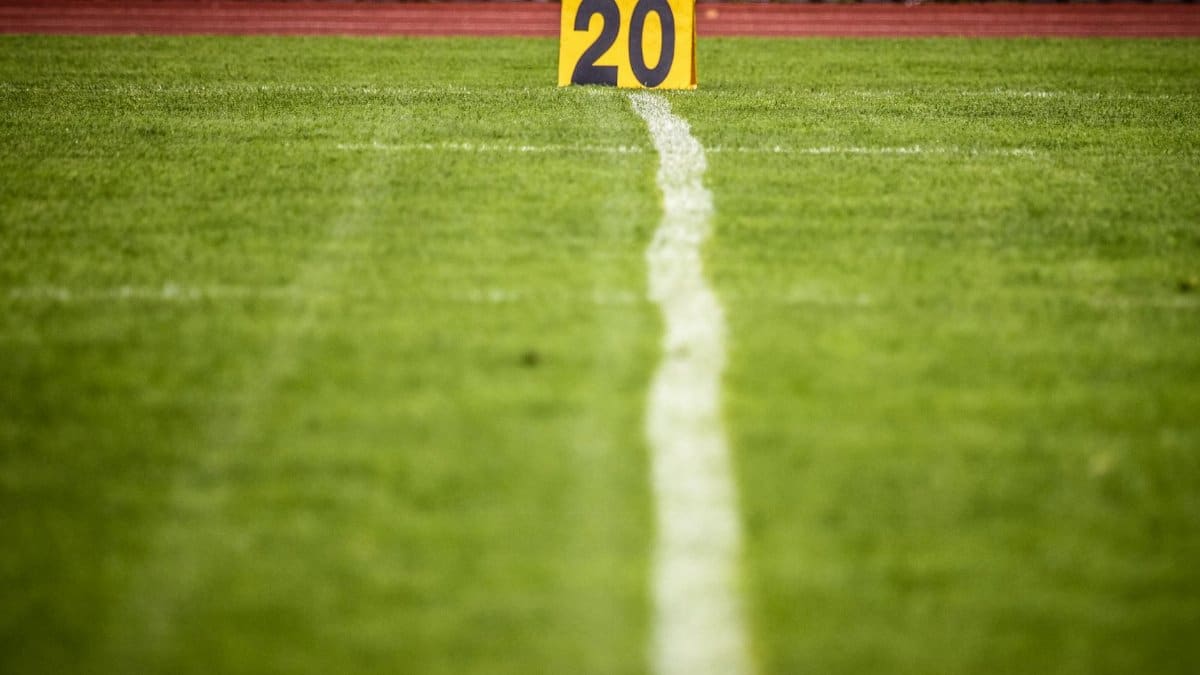 Close-up view of a football field with a 20-yard marker, showcasing vibrant green grass.