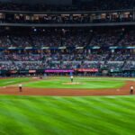 An engaging baseball game with a full crowd at Texas stadium under bright lights.