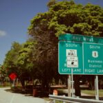 Directional sign for Key West, Florida on a clear day. Green road signs guide travelers southwards.