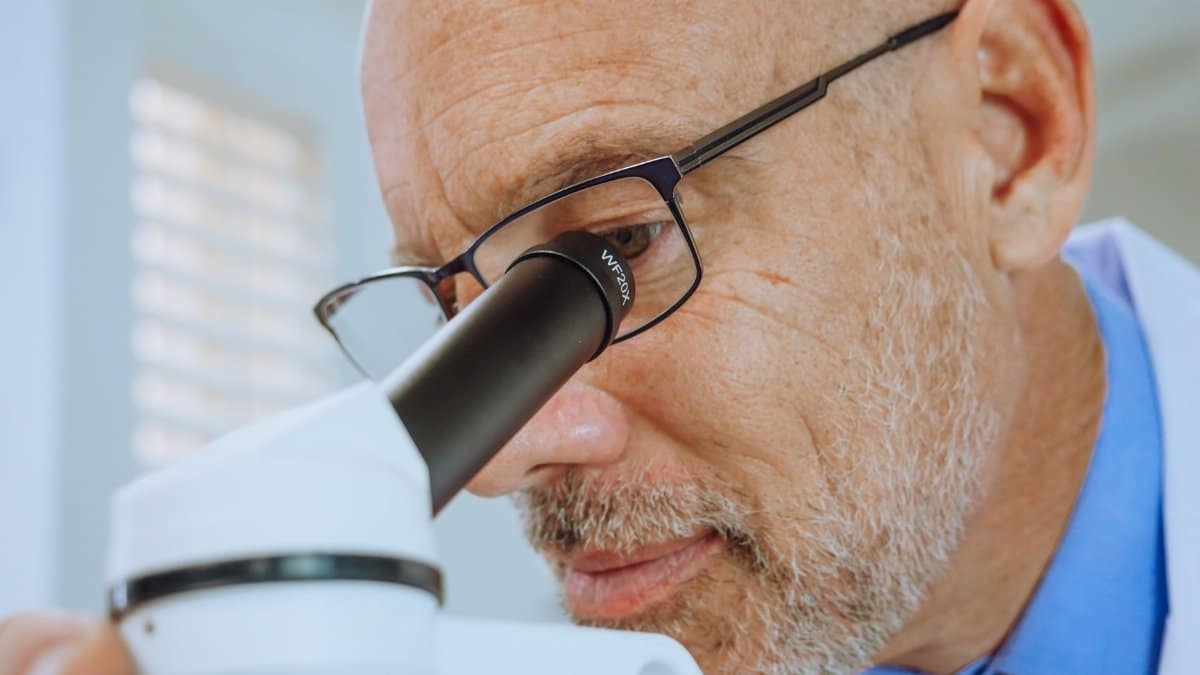 Scientist using a microscope for research in a laboratory setting.