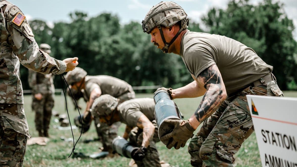 US Army soldiers engage in a rigorous outdoor training exercise at Fort Benning, demonstrating teamwork and discipline.