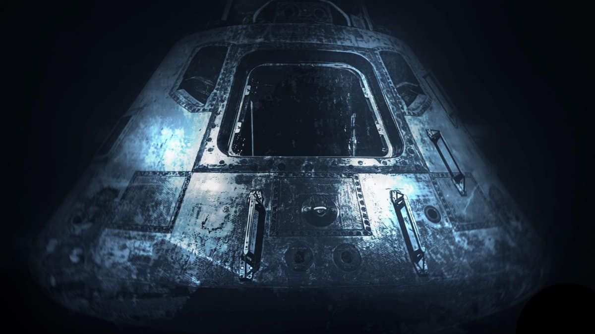 A dramatic monochrome image of an old space capsule in dim light, showcasing space exploration history.